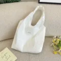 Vue détaillée du sac à bandoulière en toile blanc cassé avec des pois colorés - Sac sous le bras