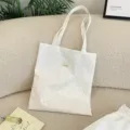 Gros plan d'un sac cabas en toile crème avec des pois bleus et rouges sur un canapé beige. - Sac Cabas à Bandoulière