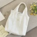 Gros plan sur un sac en toile à pois crème avec une élégante décoration de nœud en dentelle. - Sac Sous le Bras (Avec Nœud en Dentelle)