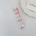 Dettaglio dell'organizzatore per cavi a quadri macaron con bottone a pressione a cuore rosa - Quadretti Blu Rosa Sakura