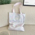 Detailansicht der pastellfarbenen karierten Canvas-Tasche in Rosa und Blau auf Sofa - Schultertasche