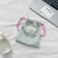 Detailed macro view of a mint green polka dot satin drawstring pouch with pink cords - Light Green