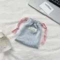 Close-up view of a light blue satin polka dot drawstring pouch for jewelry storage - Light Blue