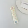 Dettaglio dell'organizzatore cavi in maglia floreale con bottone a cuore - Velluto a Coste Rosa Fior di Pesco
