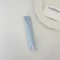 Primo piano di fascetta in tessuto azzurro a pois con un simpatico bottone a cuore - Raso Blu Chiaro a Pois