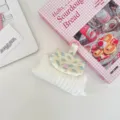 Detailed close-up of a floral quilted mini pouch with pink snap button and keyring hook - White