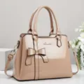 Elegant nude patent leather handbag featuring a chic bow detail and gold-tone hardware accents. - Khaki
