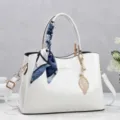 Elegante borsa a mano in pelle verniciata bianca con sciarpa decorativa e ciondolo a foglia - Bianco avorio