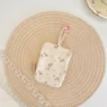 Detail van de bloemige sleuteletui, draagbare canvas opbergtas voor oortjes met dubbele rits. - Beige