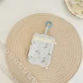 Detail van het kleine bloemenetui met dubbele rits en blauwe sleutelring voor gebruik. - Blauw