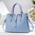 Élégant sac à main bleu texturé avec serrure métallique et compartiments spacieux. - Bleu
