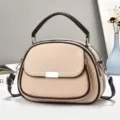 Detailaufnahme einer stilvollen beigen Damenhandtasche mit braunen Akzenten und Tragegriff. - Khaki
