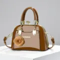 Borsa a mano a conchiglia in pelle verniciata marrone con ciondolo a fiore e dettagli dorati. - Giallo ocra