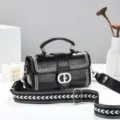 Black soft leather women's shoulder crossbody bag with top handle and wide patterned strap. - Black