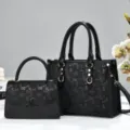 Detailed view of black monogram tote handbag set, featuring structured design and dual handles. - Black
