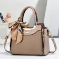 Vista dettagliata della borsa a tracolla da donna con tessuto testurato, foulard e targa in metallo. - Kaki