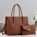 Detail view of brown leather tote bag with matching envelope pouch and double handles. - Earthy Yellow