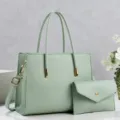 Detailed view of mint green PU leather tote bag with matching clutch and gold hardware. - Green