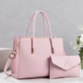 Detailed view of the elegant pink leather tote bag with matching clutch, showcasing fine texture. - Pink