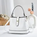 Vue détaillée du sac seau blanc effet croco avec serrure métallique et poignée élégante. - Blanc