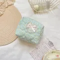 Close-up detail of the quilted cosmetic pouch showing blue yellow plaid and lace bow. - Cyan Yellow Plaid