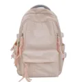 Primo piano dettagliato dello zaino studentesco rosa con delicati ricami e nappe. - Rosa