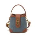 Vue rapprochée du mini sac seau en denim avec bordure en cuir marron et fermoir doré chic. - Cowboy