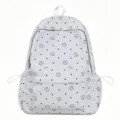 White student backpack detail showcasing cute star prints, black dots and front pocket. - L / White