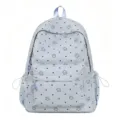 Detailed front view of light blue nylon student backpack with cute smiling stars and dots pattern. - Blue
