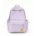 Detailed view of the light purple nylon backpack featuring floral embroidery and front pocket. - Purple