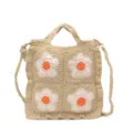Dettaglio in primo piano della borsa in crochet beige con vivaci motivi floreali bianchi. - Bianco avorio