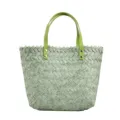 Close-up view of green woven straw tote bag for women with stylish light green handles. - Green