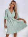 Close-up detail of a V-neck short sleeve wrap dress with waist tie and spot print. - S / Light Green