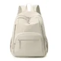 Sac à dos minimaliste en nylon beige avec plusieurs poches zippées pour le quotidien. - Blanc Cassé