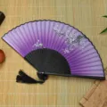 Vue détaillée d'un éventail pliable chinois violet traditionnel avec motif de fleurs de prunier. - Style 4