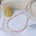 Nahaufnahme der exquisiten rosa Perlenkette mit goldenen Abstandshaltern und Perle. - Rosenquarz Perlenkette