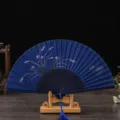 Blue silk folding fan with floral pattern and wooden handle, elegant retro style variant. - Blue Bone Blue Surface Orchid / Blue