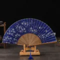 Retro folding fan with blue silk cherry blossom pattern, wooden ribs and elegant tassel stand. - Brown Bone Blue Surface Cherry Blossom / Blue