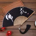 Traditional Chinese style folding fan with black surface, white calligraphy and black tassel. - 08 Buddhist Precepts