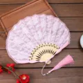 Elegante ventaglio pieghevole in pizzo rosa con stecche di legno e nappina per matrimonio. - Stile G