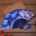 Éventail pliant floral bleu traditionnel avec pompon, idéal pour la danse Hanfu et la photo. - A02