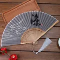 Traditional Chinese folding fan with linen fabric, bamboo ribs, and elegant tassel pendant. - 13 Coolness