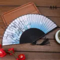 Vue détaillée d'un éventail pliant chinois traditionnel avec motif de fleurs de prunier. - A16