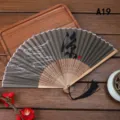Abanico plegable vintage chino de bambú con borla negra, perfecto para danza y decoración. - Caligrafía Tradicional (A19)
