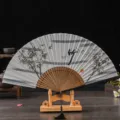 Traditional Chinese folding fan with linen fabric surface, bamboo ribs and wooden display stand. - No. 5 Grey Surface Bamboo