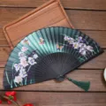 Chinese style silk folding fan with dark green floral pattern and green tassel variant. - Style E