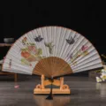 Traditional Chinese folding fan with elegant floral and butterfly print on wooden stand. - No. 7 Colorful Butterflies