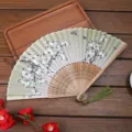 Élégant éventail pliant classique avec motif floral, monture en bambou et gland vert. - A14