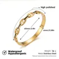Brazalete rígido de cadena ancla en acero inoxidable dorado con detalle negro y medidas. - Brazalete de esmalte con eslabones de ancla