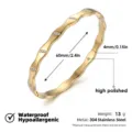 Pulsera rígida de acero inoxidable dorado ondulado con cristales brillantes elegantes. - Brazaletes de ondas segmentadas con strass brillante